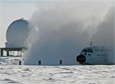 An LC130 cargo airplane at Amundsen-Scott South Pole Station. The dome in the background shelters a communications satellite dish for the MARISAT-2 satellite.