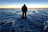 A person stands silhouetted by the South Pole sunset in early April 2008.  Photo: Calee Allen, National Science Foundation