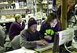 Photo of people in front of a laptop computer.
