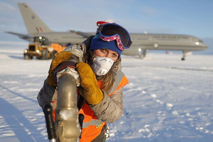 Fuels operator carries fuel hose to jet